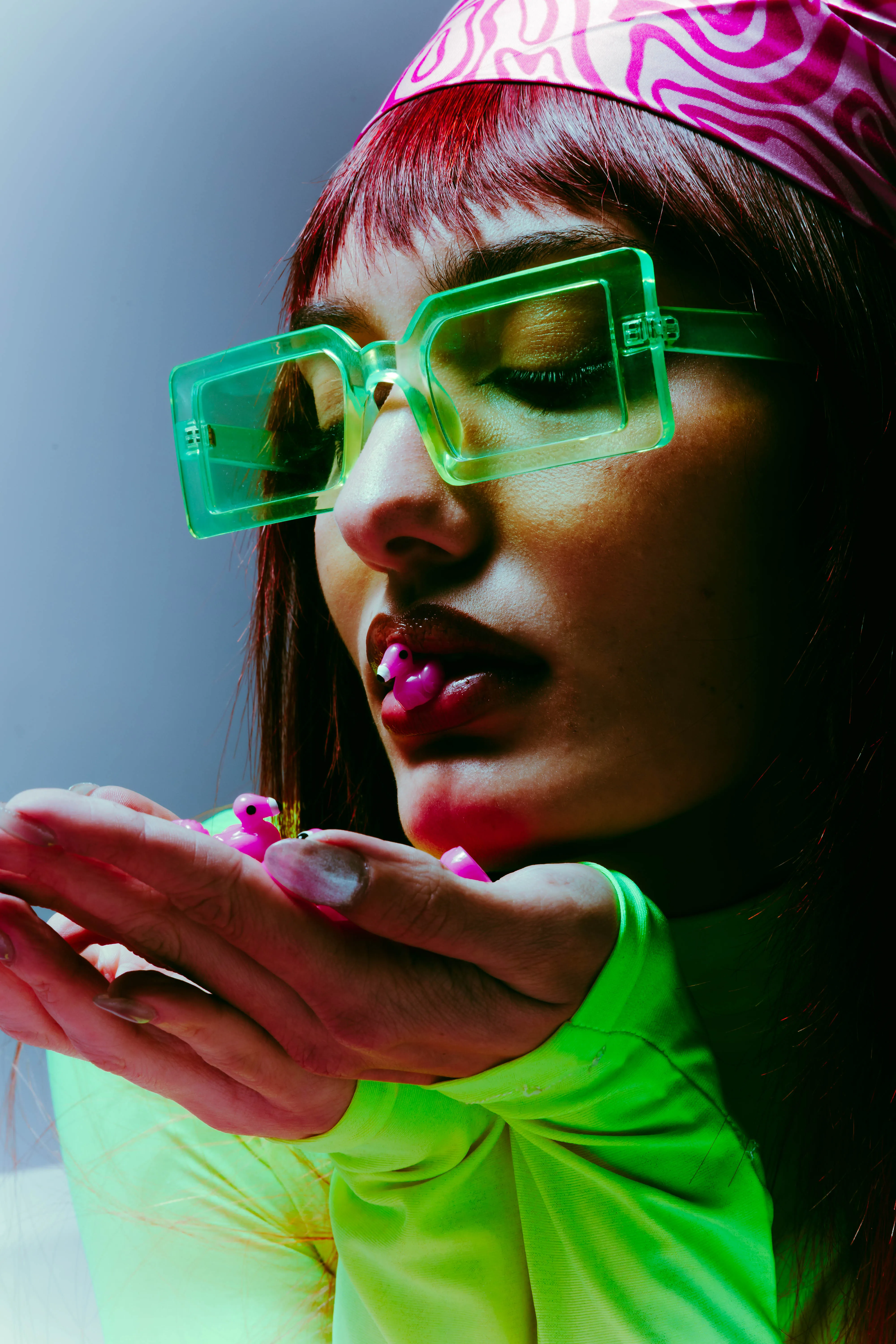 Close-up of model with neon green sunglasses and pink bandana